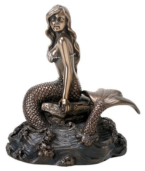 Mermaid sitting on rock in water looking into the horizon